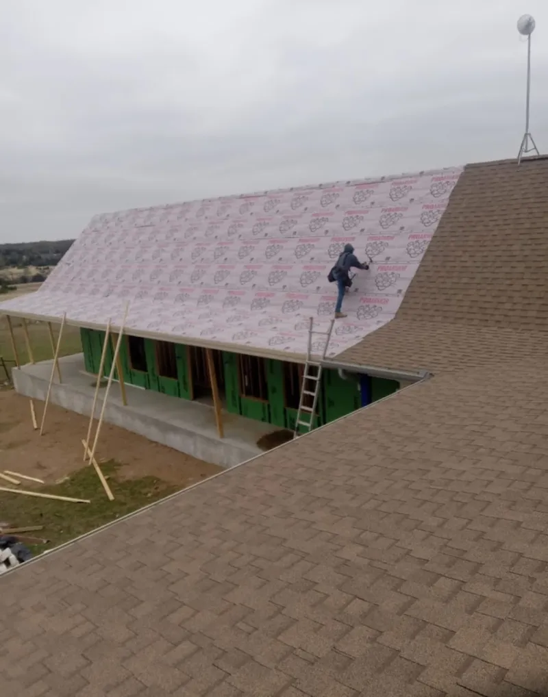 Worker preparing underlayment for a metal roof installation in Lugoff